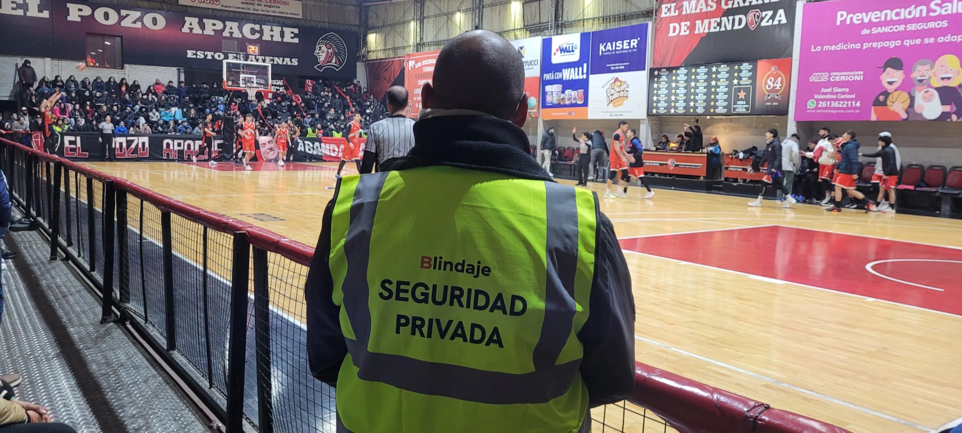 Guardia de seguridad de Blindaje, al lado de una cancha de basketball, controlando un partido de semifinal del Torneo Superliga, en la cancha de Atenas Sport Club, Mendoza, Argentina.